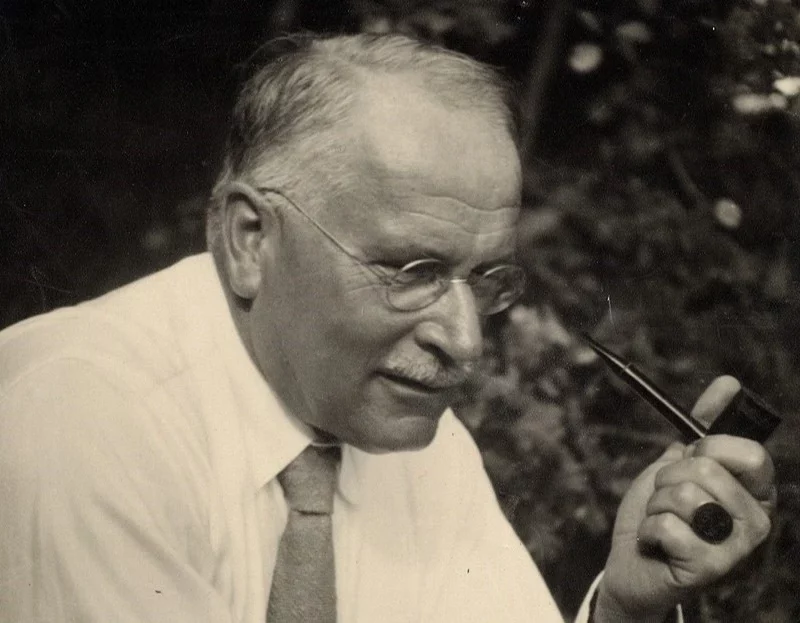 Swiss psychiatrist and psychotherapist Karl Jung holding a smoking pipe