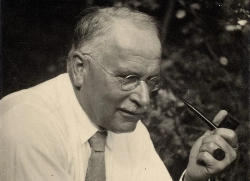 Swiss psychiatrist and psychotherapist Karl Jung holding a smoking pipe