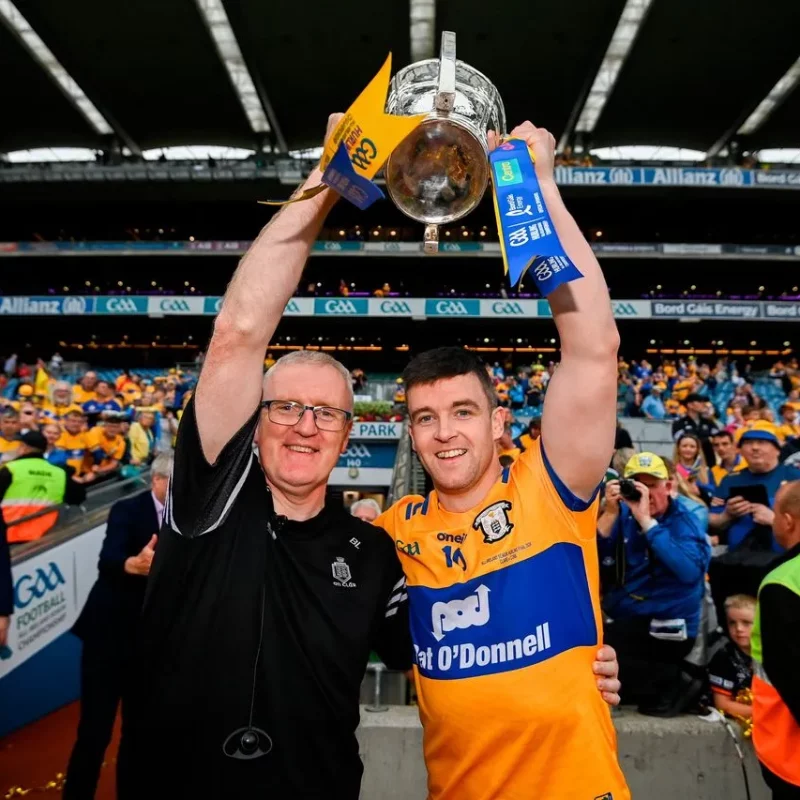 Clare Hurling Manager and Team Captain raise winning hurling all ireland trophy over their heads.