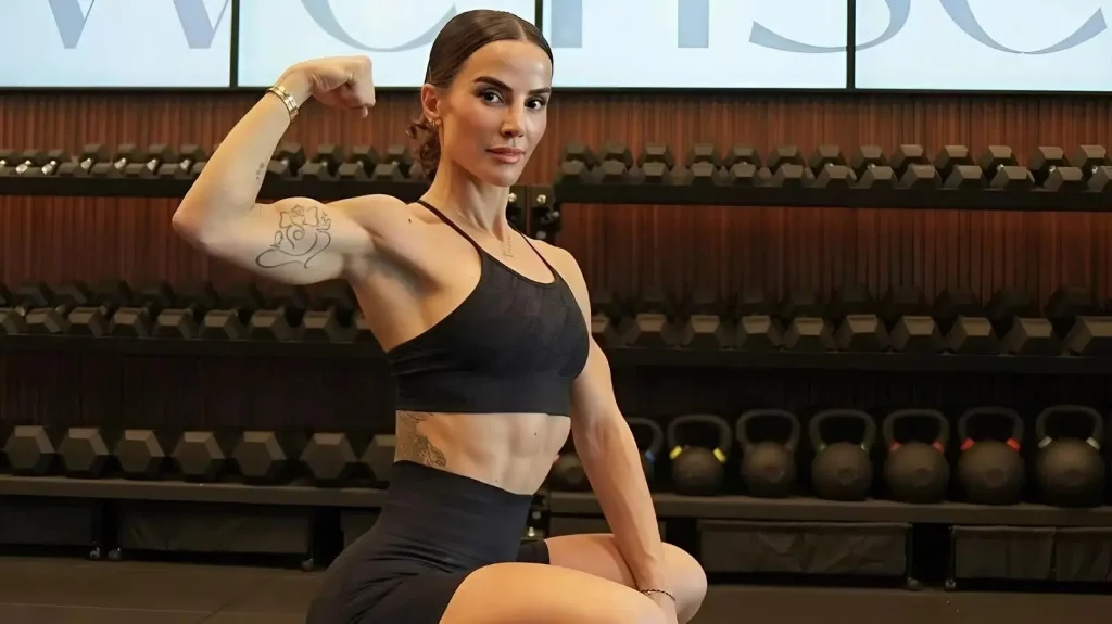 Image of woman flexing her bicep in a gym