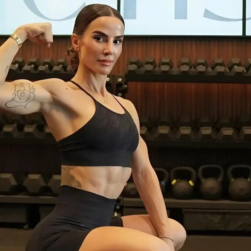 Image of woman flexing her bicep in a gym