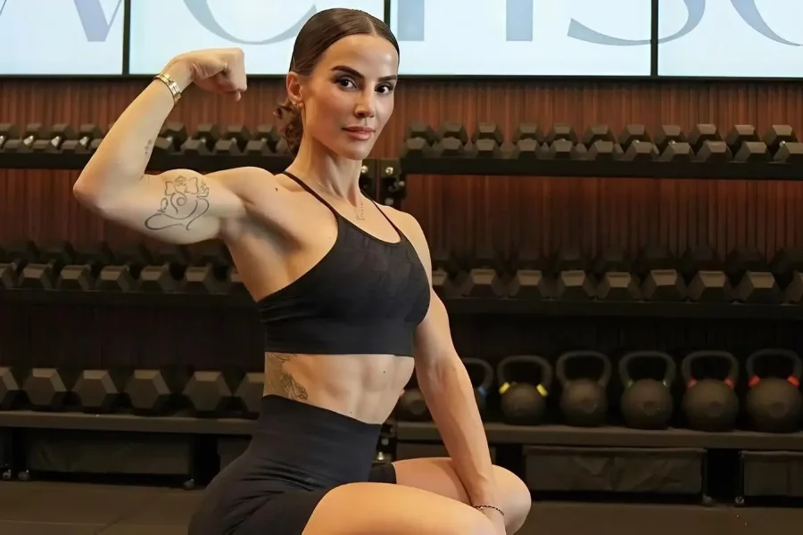 Image of woman flexing her bicep in a gym