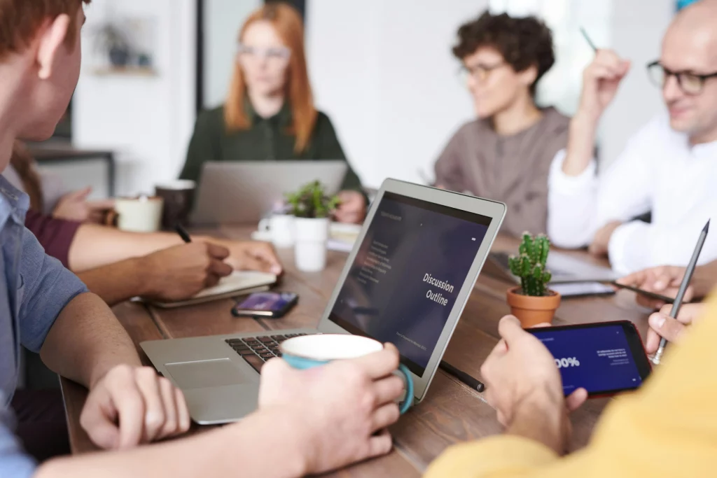 Group of people sitting at a table having a hybrid work meeting