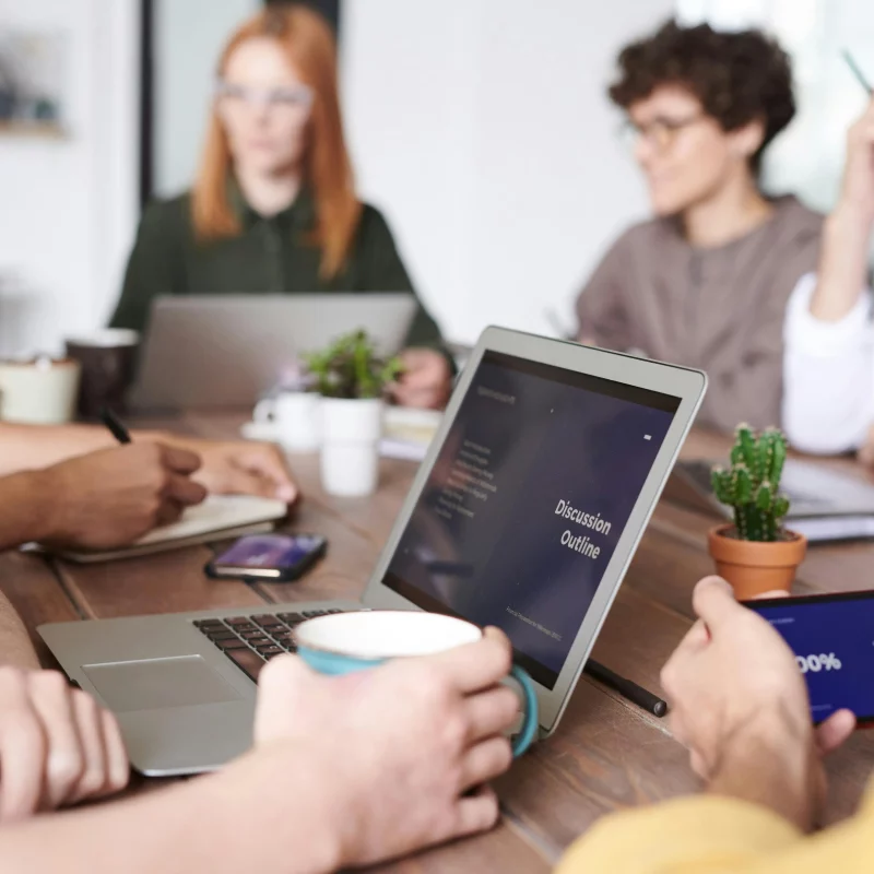 Group of people sitting at a table having a hybrid work meeting