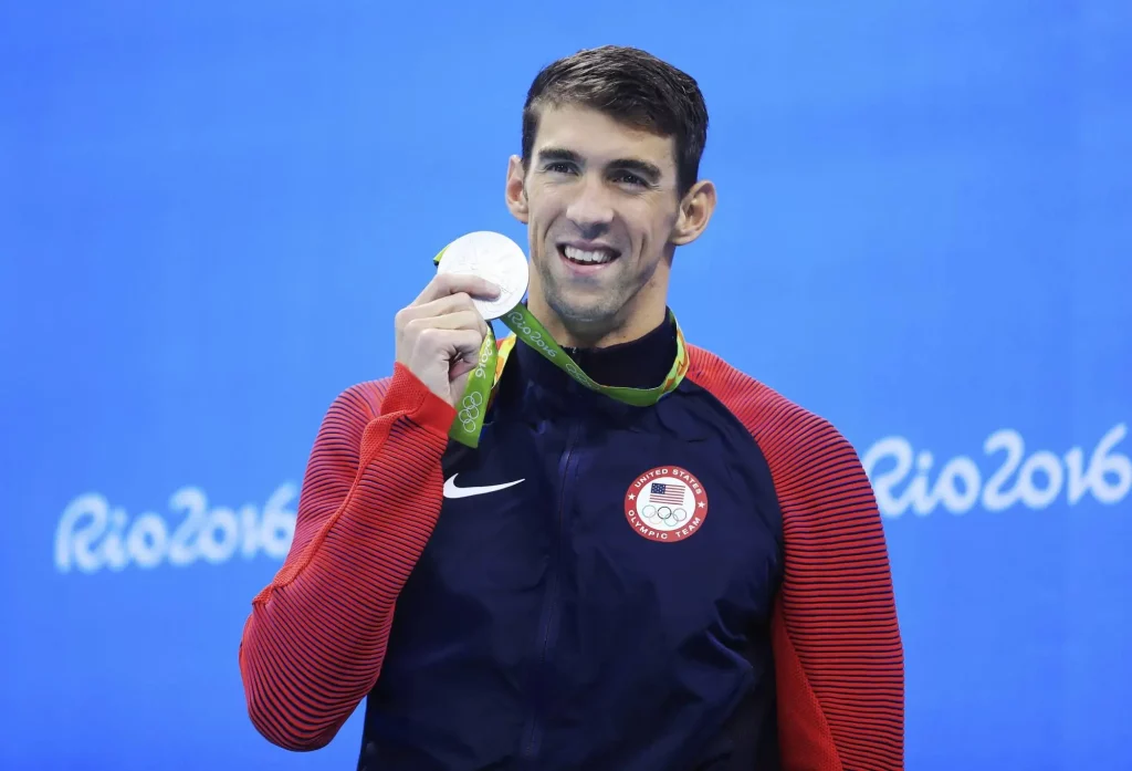 Michael Phelps olympian swimmer holding up his medal at the Rio 2016 Olympics