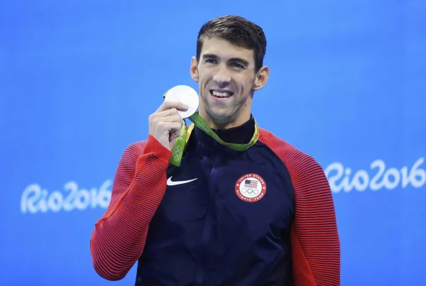 Michael Phelps olympian swimmer holding up his medal at the Rio 2016 Olympics