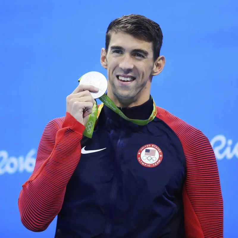 Michael Phelps olympian swimmer holding up his medal at the Rio 2016 Olympics