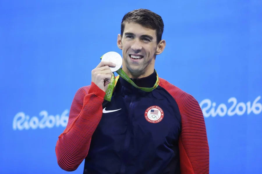 Michael Phelps olympian swimmer holding up his medal at the Rio 2016 Olympics