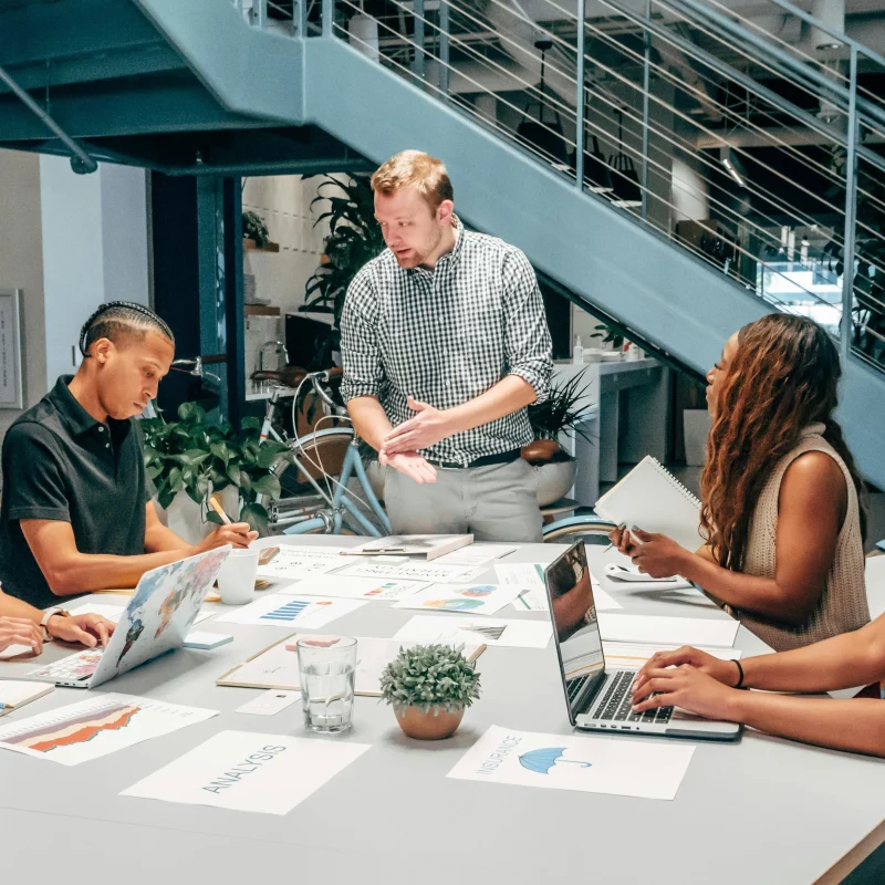 5 people sat down at a table having a work meeting