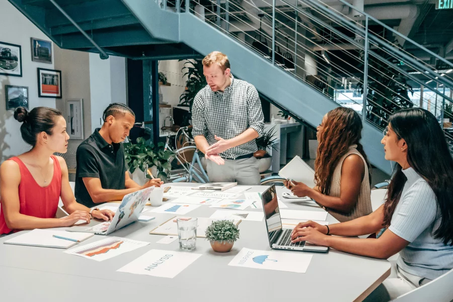 5 people sat down at a table having a work meeting